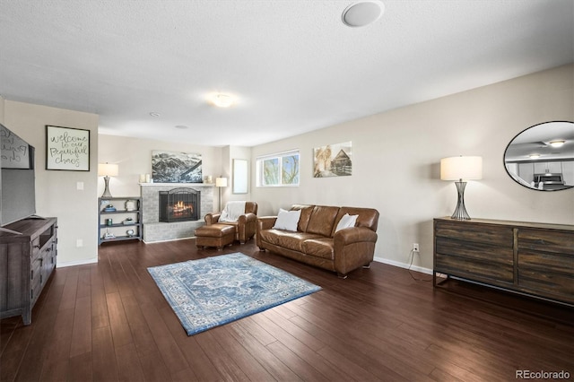 living room with wood finished floors, a fireplace, and baseboards