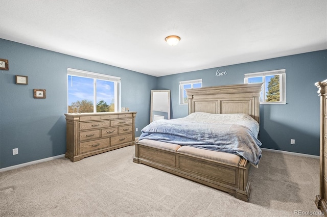 bedroom featuring baseboards and light carpet