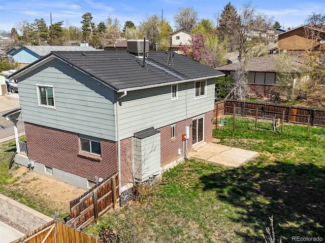 back of property featuring a patio, central AC unit, a fenced backyard, a yard, and brick siding