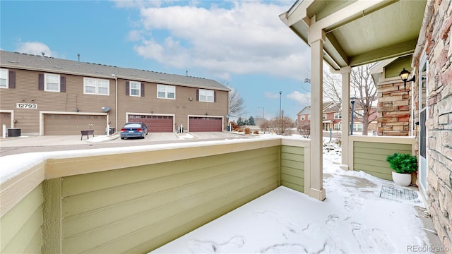 snow covered patio with a residential view and central AC