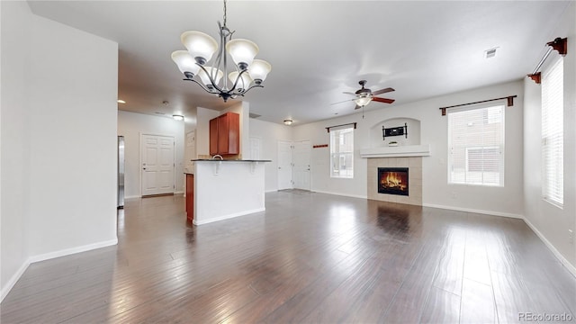 unfurnished living room featuring dark wood-style floors, plenty of natural light, and a fireplace