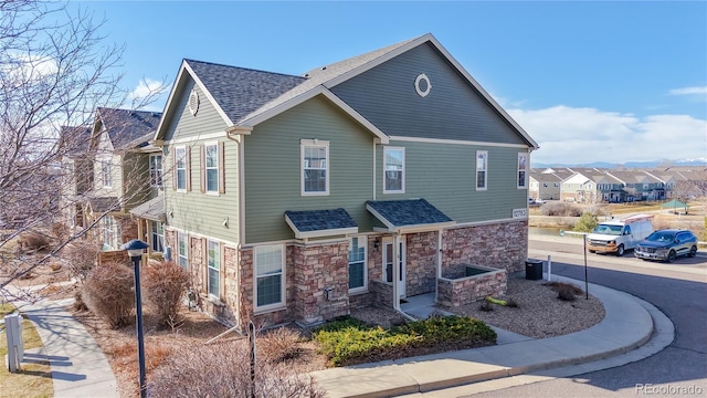 view of front of home featuring stone siding and a shingled roof