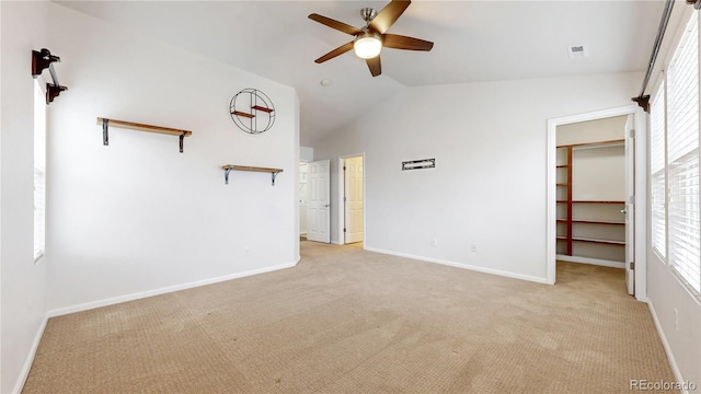 unfurnished living room with vaulted ceiling, a ceiling fan, baseboards, and light carpet