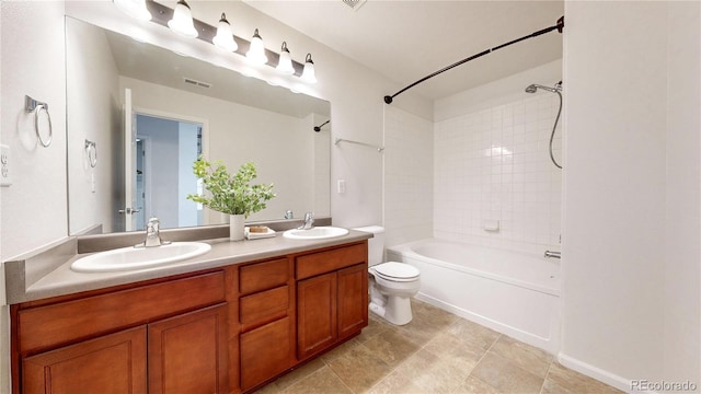 full bathroom featuring double vanity, toilet, bathing tub / shower combination, and a sink