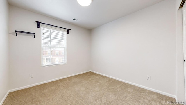 unfurnished room with visible vents, baseboards, and light colored carpet