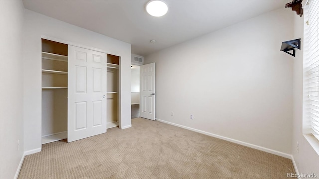 unfurnished bedroom featuring carpet flooring, baseboards, visible vents, and a closet