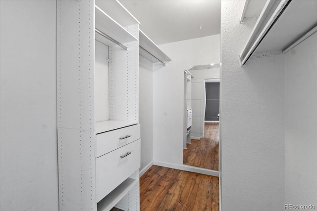 walk in closet with wood finished floors
