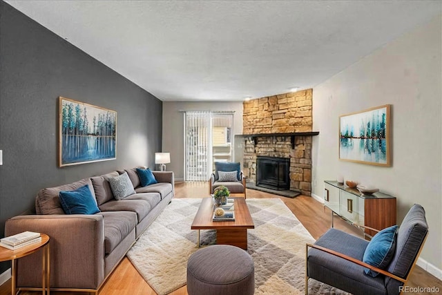 living room with wood finished floors, a fireplace, and baseboards