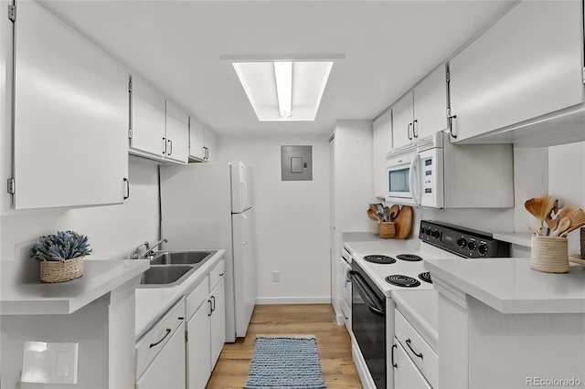 kitchen featuring a sink, electric range, white microwave, light countertops, and light wood-style floors