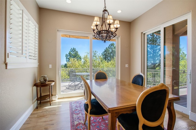 dining area featuring light wood-type flooring and a chandelier