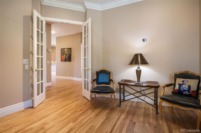 sitting room with light wood-type flooring, french doors, and ornamental molding