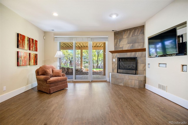 interior space featuring hardwood / wood-style floors and a tiled fireplace