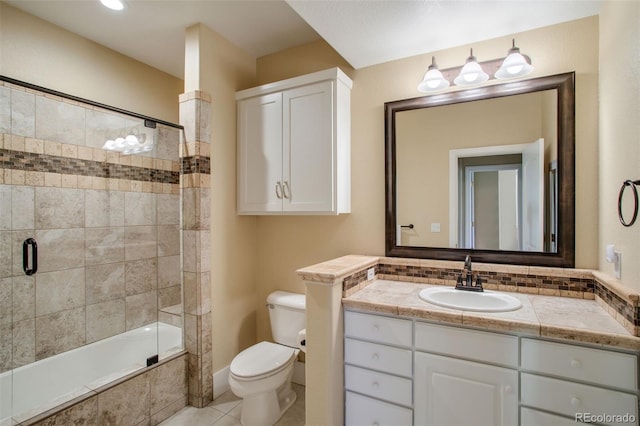 full bathroom featuring toilet, combined bath / shower with glass door, tasteful backsplash, tile patterned floors, and vanity