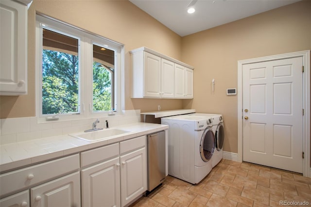 laundry area featuring sink, separate washer and dryer, and cabinets