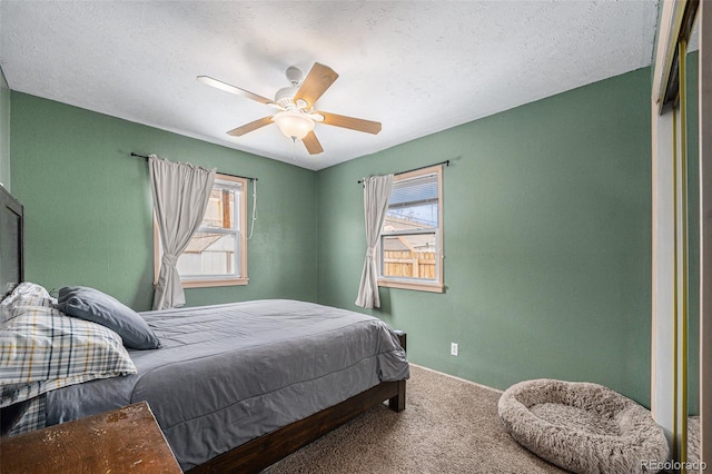 bedroom featuring ceiling fan, carpet flooring, and a textured ceiling