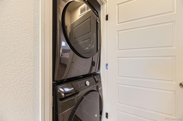 18270 E 51st Pl, Denver, CO 80249 - laundry area featuring stacked washer / drying machine and a textured wall