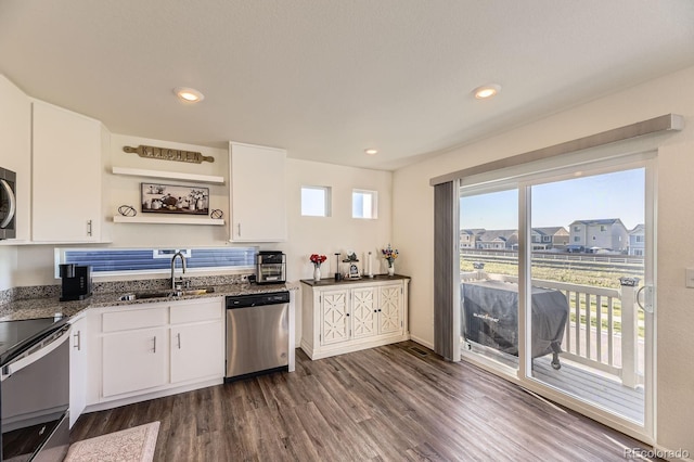 18270 E 51st Pl, Denver, CO 80249 - kitchen with appliances with stainless steel finishes, a sink, dark wood-style floors, white cabinets, and dark stone countertops