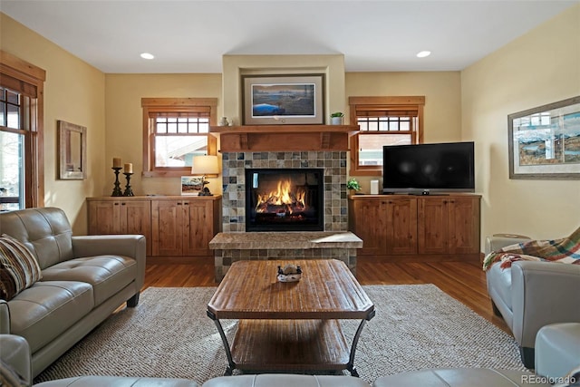 living area with recessed lighting, dark wood-style flooring, and a glass covered fireplace