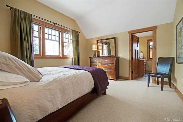 bedroom with light colored carpet, vaulted ceiling, and baseboards