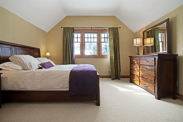 bedroom featuring lofted ceiling, baseboards, and light colored carpet