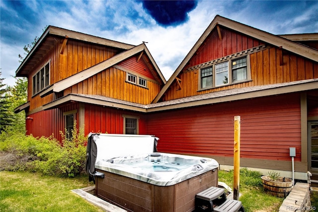 back of property featuring a hot tub