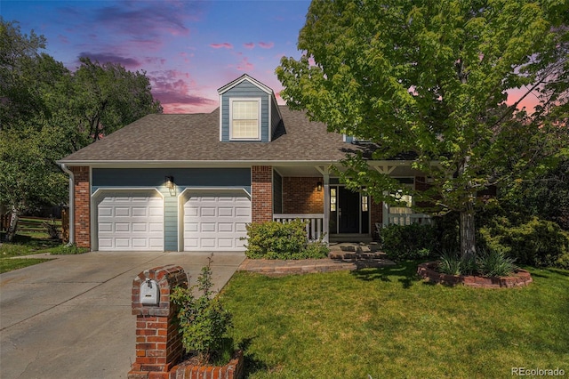 10247 W Roxbury Pl, Littleton, CO 80127 - view of front of home featuring concrete driveway, a garage, a front yard, and brick siding