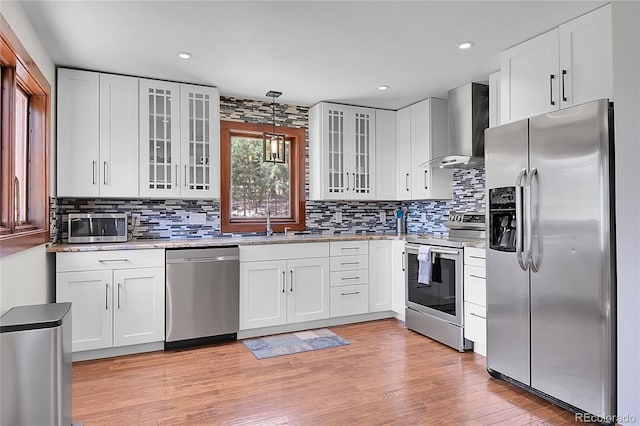 700 Rosalie Rd, Bailey, CO 80421 - kitchen featuring appliances with stainless steel finishes, wall chimney range hood, tasteful backsplash, white cabinetry, and recessed lighting