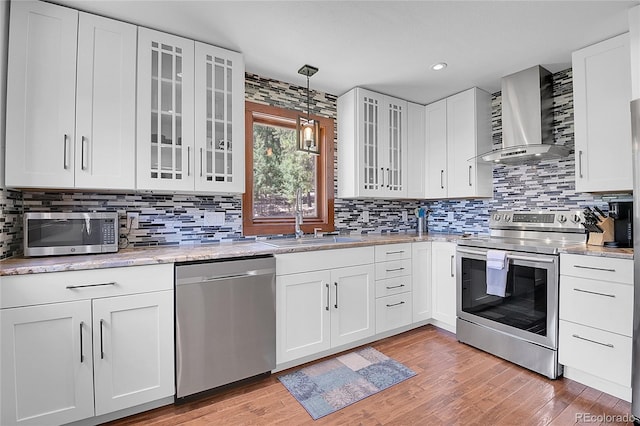 700 Rosalie Rd, Bailey, CO 80421 - kitchen with appliances with stainless steel finishes, wall chimney exhaust hood, a sink, light wood finished floors, and recessed lighting
