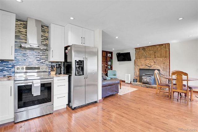 700 Rosalie Rd, Bailey, CO 80421 - kitchen with stainless steel appliances, wall chimney range hood, decorative backsplash, light wood-type flooring, and white cabinetry