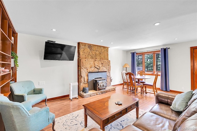 700 Rosalie Rd, Bailey, CO 80421 - living room featuring radiator, baseboards, wood finished floors, a wood stove, and recessed lighting