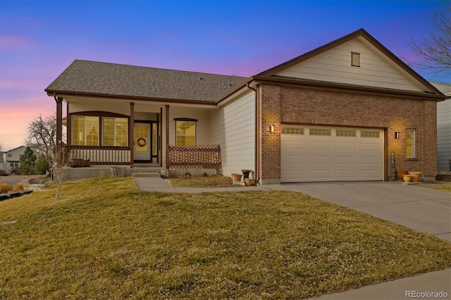 ranch-style house featuring a porch, concrete driveway, a garage, a lawn, and brick siding