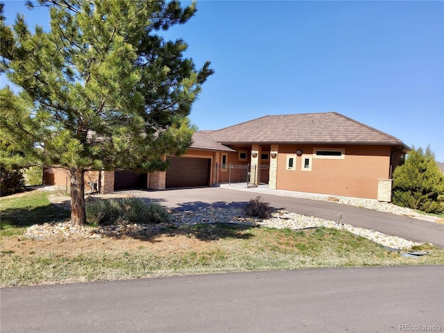 ranch-style house featuring stucco siding, driveway, and an attached garage