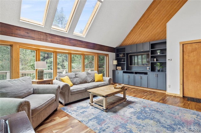 living room with a skylight, high vaulted ceiling, and light wood finished floors