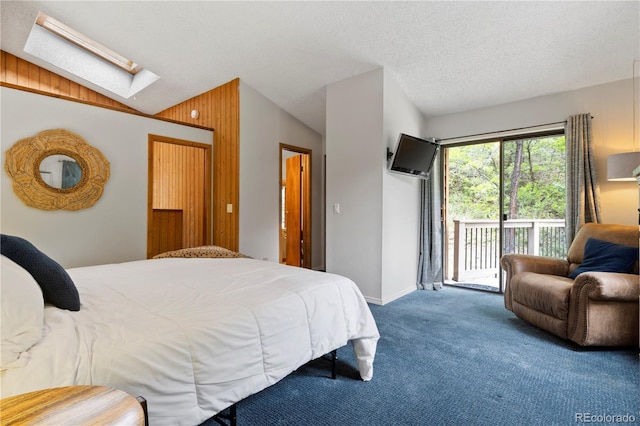 bedroom with baseboards, carpet, lofted ceiling with skylight, and access to exterior