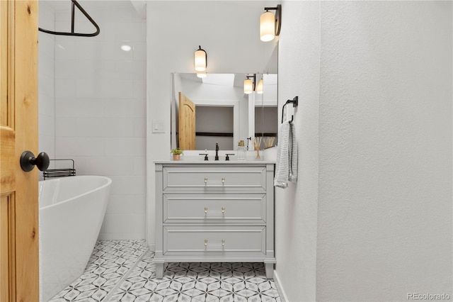full bath with tile patterned flooring, walk in shower, vanity, a textured wall, and a soaking tub