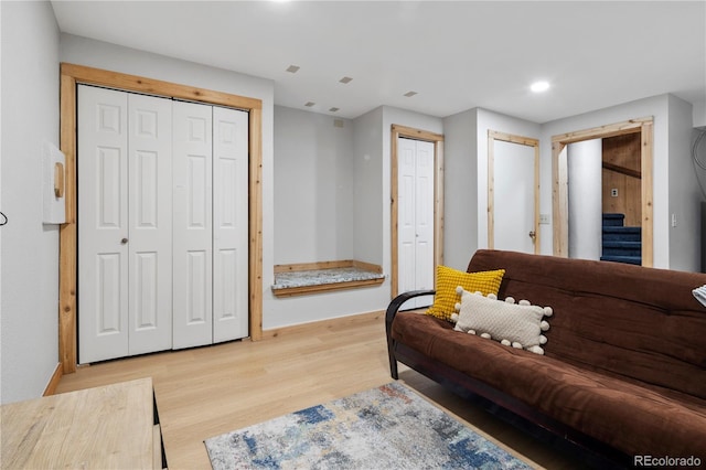 living room featuring recessed lighting, baseboards, stairs, and light wood-style flooring