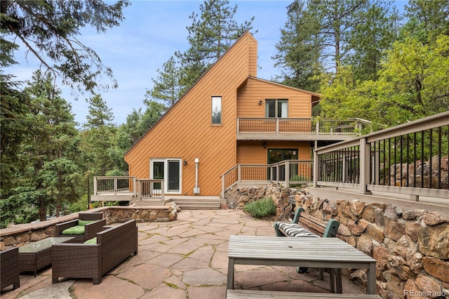 back of house featuring a balcony, a patio area, and an outdoor hangout area