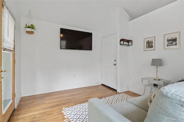 living area with baseboards, plenty of natural light, and wood finished floors