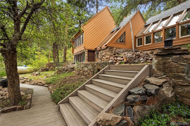 view of property exterior featuring a wooden deck and stone siding