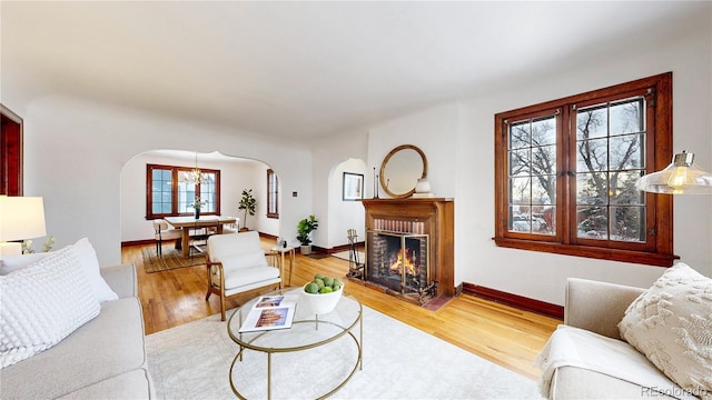 living room featuring a brick fireplace and hardwood / wood-style floors