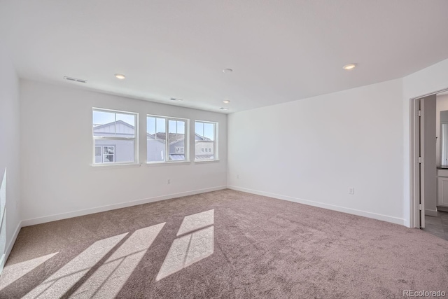 unfurnished room featuring light carpet