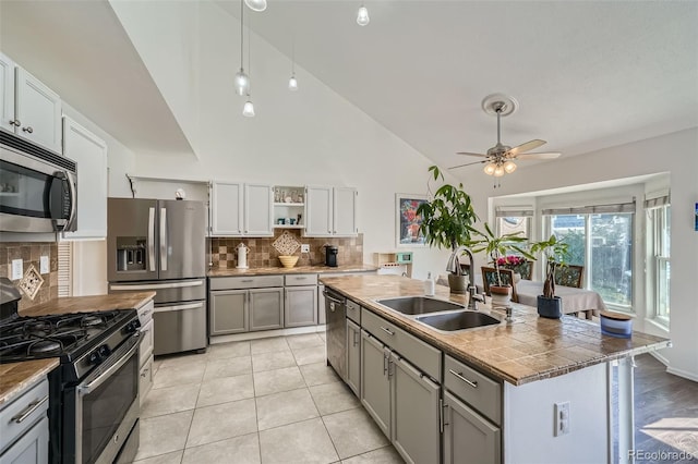 10064 Owens St, Broomfield, CO 80021 - kitchen featuring appliances with stainless steel finishes, a sink, gray cabinets, a ceiling fan, and tasteful backsplash