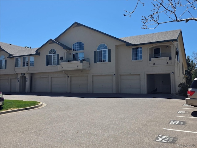 townhome / multi-family property featuring stucco siding, a garage, and a shingled roof