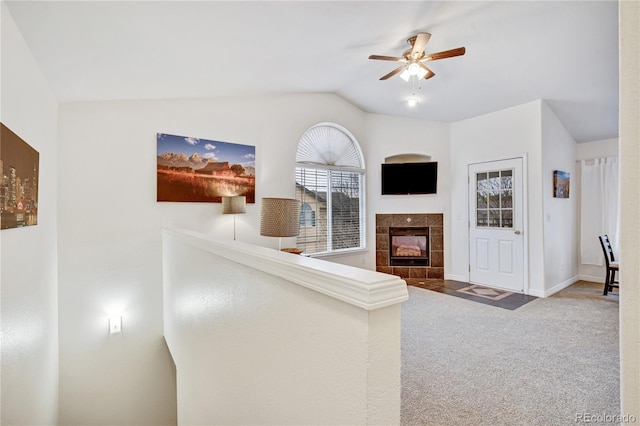 unfurnished living room featuring a fireplace, carpet floors, lofted ceiling, a ceiling fan, and baseboards