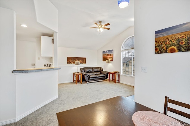 carpeted living room featuring ceiling fan, baseboards, and lofted ceiling