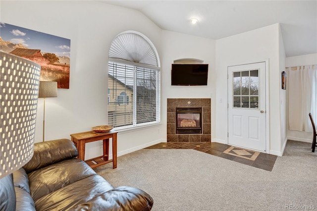 living area featuring vaulted ceiling, baseboards, carpet flooring, and a fireplace