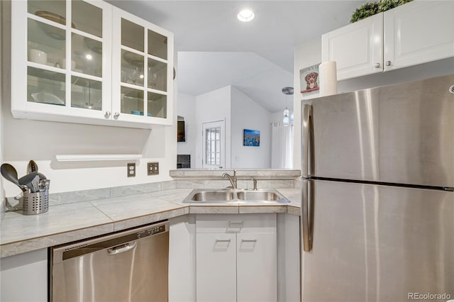 kitchen featuring appliances with stainless steel finishes, a sink, white cabinetry, glass insert cabinets, and light countertops