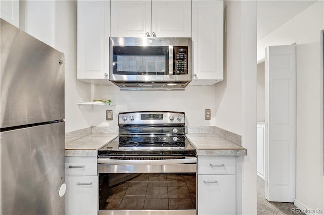 kitchen featuring appliances with stainless steel finishes, light countertops, and white cabinetry