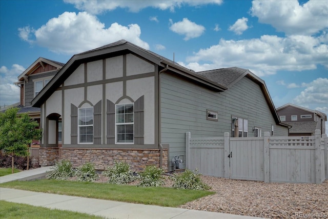 6612 N Ceylon St, Denver, CO 80249 - view of home's exterior featuring a gate, stone siding, and stucco siding