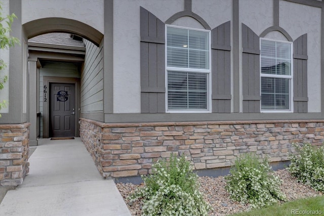 6612 N Ceylon St, Denver, CO 80249 - doorway to property featuring stone siding and stucco siding